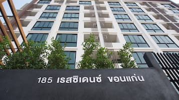 A modern building with a sign indicating the address 185 Isanburi Road.