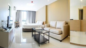 A modern hotel room with a bed, sofa, and a TV on a stand. - 185 Residence (Khon Kaen)