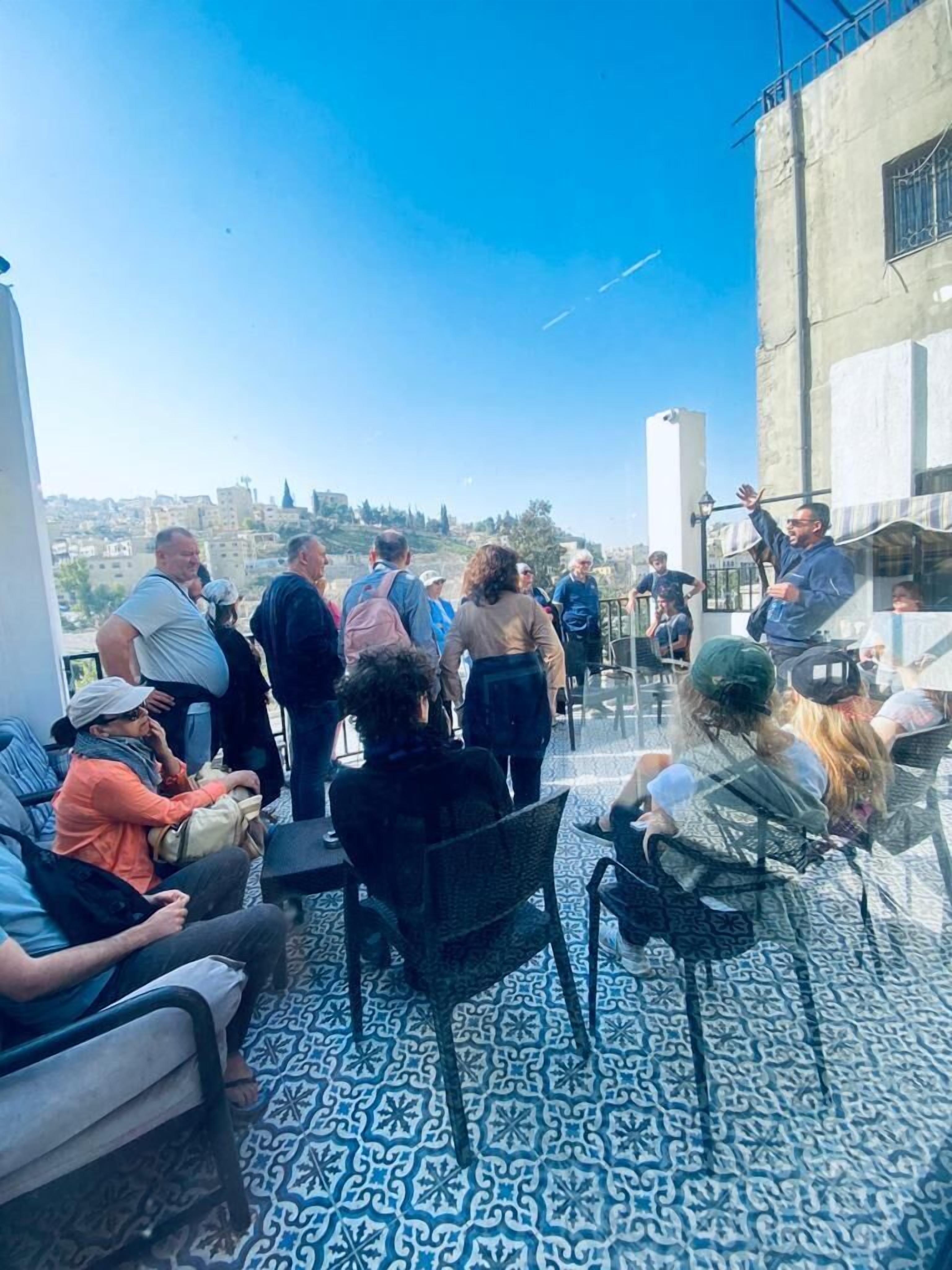 Una terraza en la azotea con suelo estampado, arreglos de asientos y vistas de la ciudad.