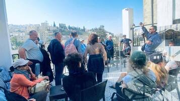Una terraza en la azotea con suelo estampado, arreglos de asientos y vistas de la ciudad.