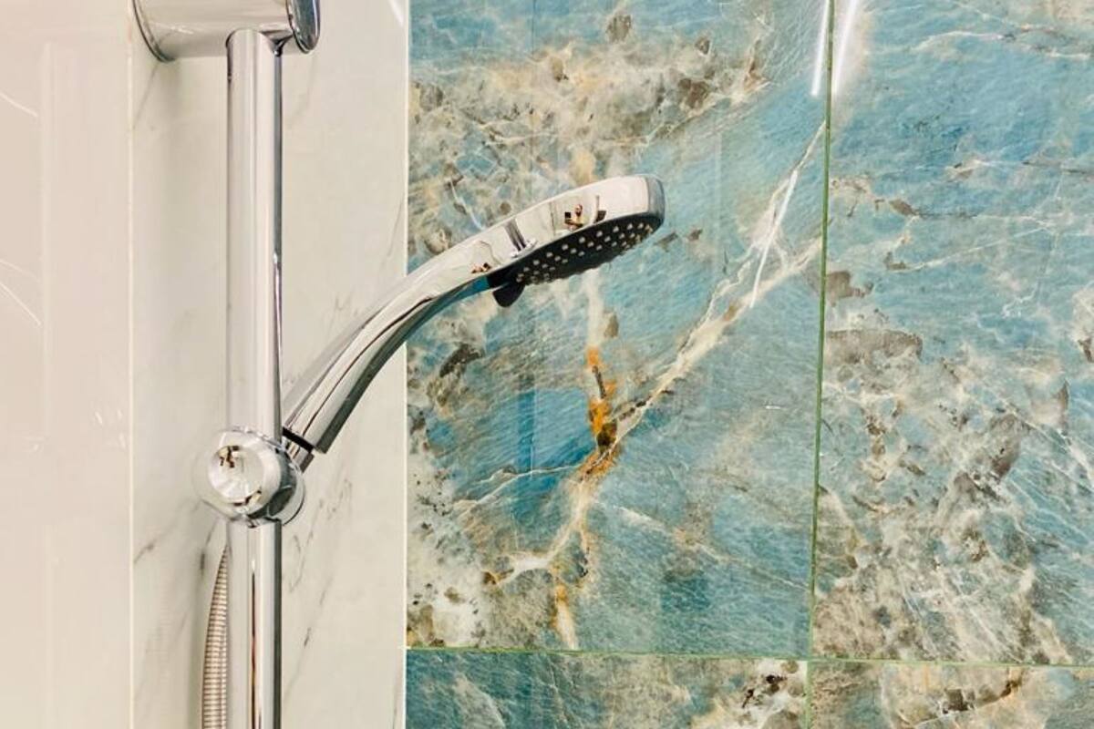 A shower with a chrome finish, a handheld showerhead, and a flexible hose.
