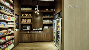 Un supermercado bien surtido con estanterías de madera, un microondas y un refrigerador.