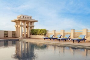 Una piscina al aire libre, tumbonas