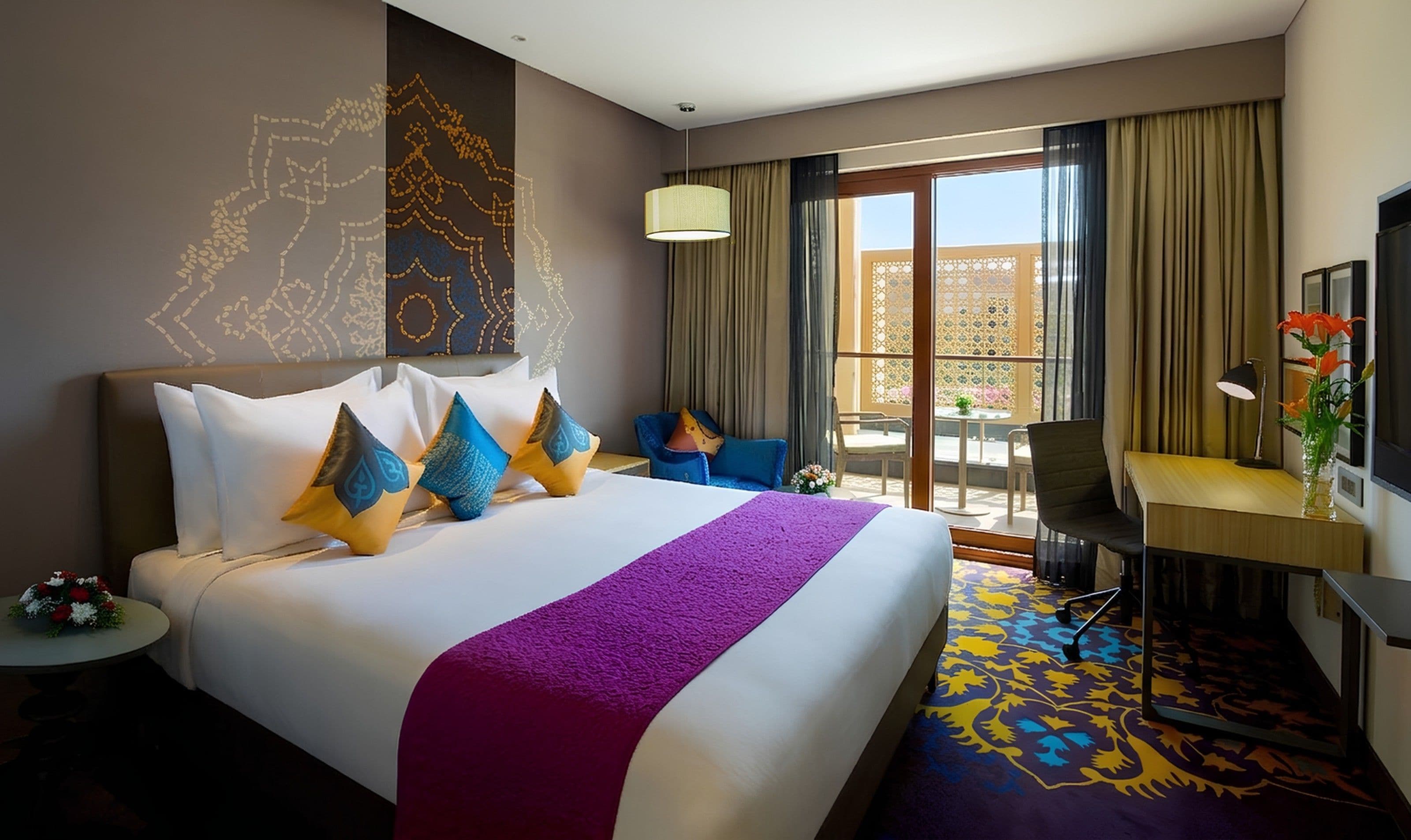 Une chambre d’hôtel avec un grand lit, un bureau, une chaise, une fenêtre avec des rideaux et un élément décoratif mural.