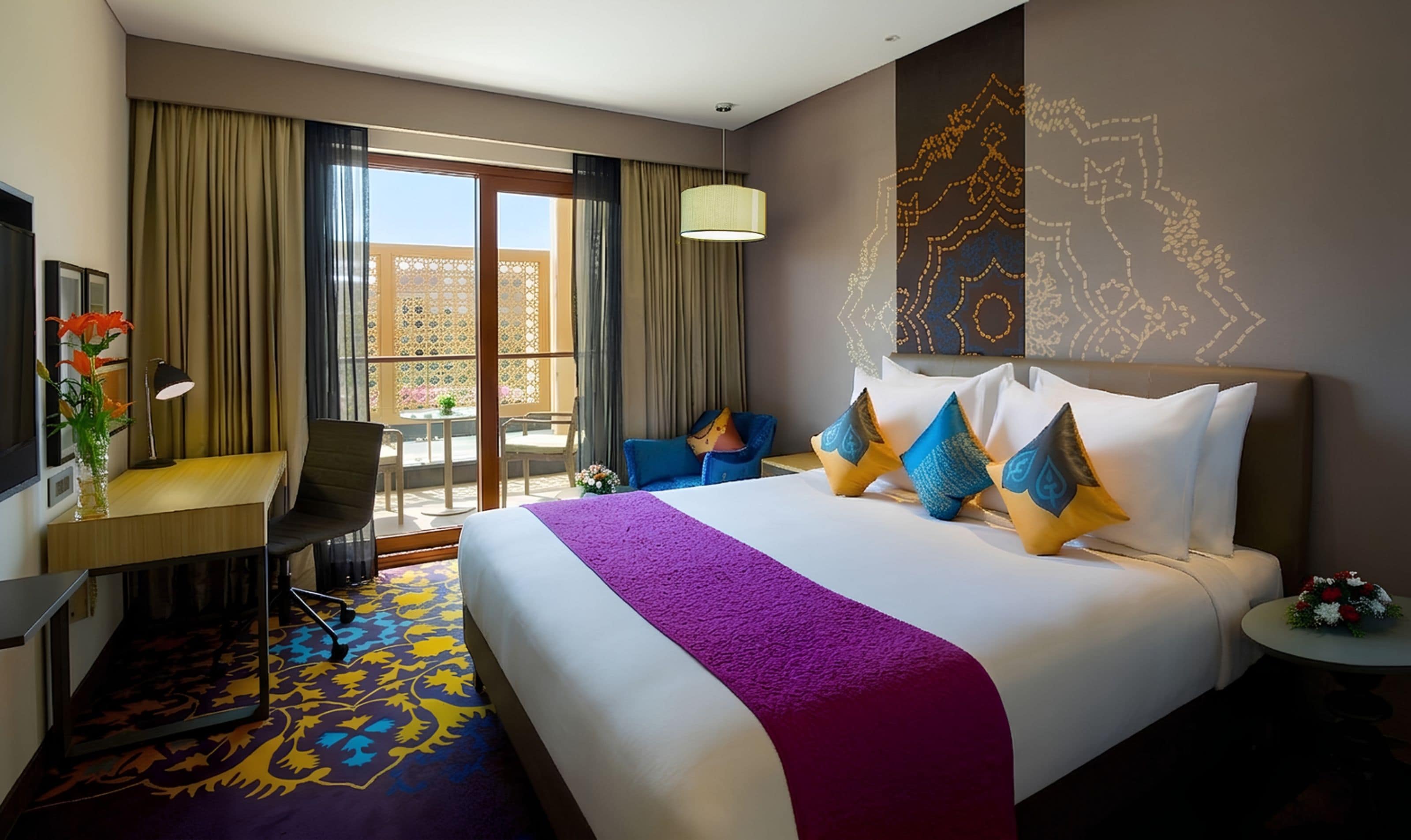 A hotel room with a large bed, a desk, a chair, a desk lamp, and a view of the outdoors.