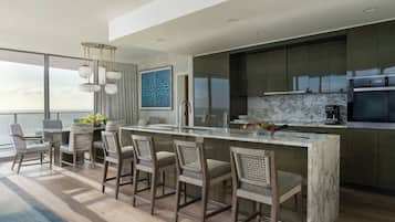 A modern kitchen with a marble countertop, a built-in oven, and a large window overlooking a scenic view.