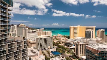 A high-rise hotel with multiple floors, a central courtyard, and a view of the ocean.