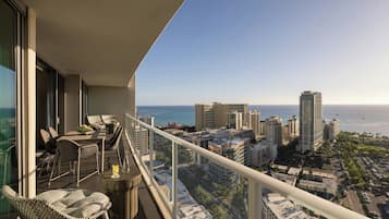A balcony with a city view, outdoor furniture, and a railing.