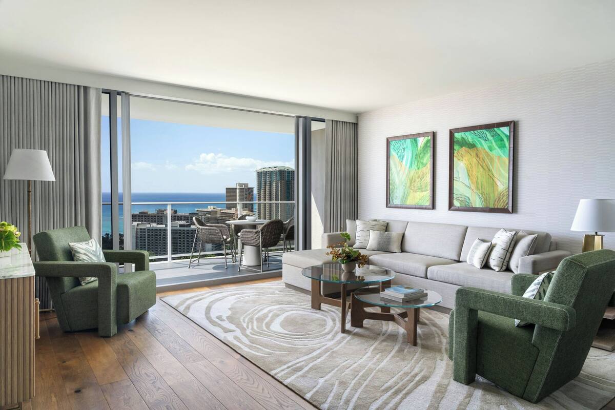A modern living room with a large window, a sofa, two armchairs, and a coffee table.