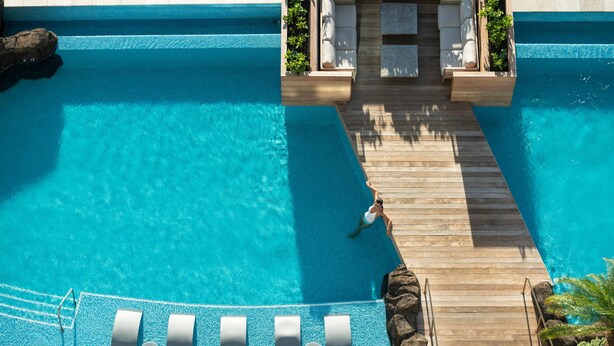 A clear blue pool with wooden deck and lounge chairs. - The Ritz-Carlton Residences, Waikiki Beach (Honolulu)