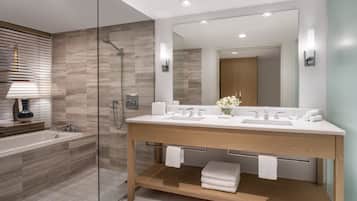 A modern bathroom with a glass-enclosed shower, a wooden vanity, and a large mirror.