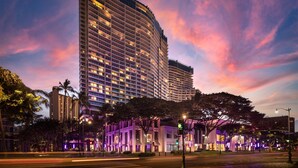 A high-rise hotel with multiple floors, a well-lit facade, and a surrounding urban environment with trees and streetlights. - The Ritz-Carlton Residences, Waikiki Beach (Honolulu)