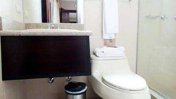A bathroom with a toilet, a sink, and a shower.