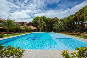 Una piscina al aire libre, sillones reclinables de piscina