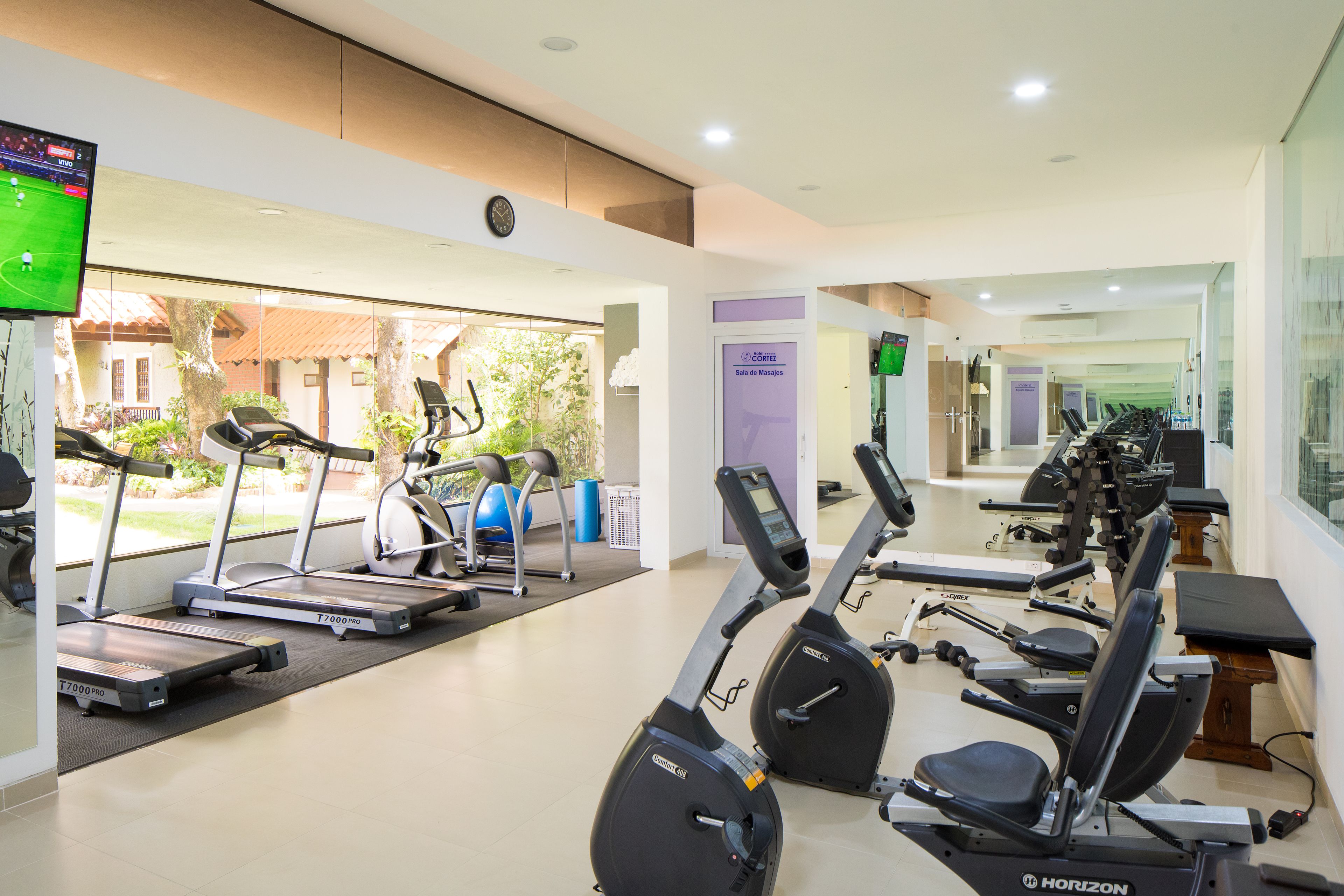 A gym with treadmills, stationary bikes, and exercise equipment.