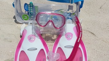 Un bolso de playa con frente de plástico transparente y correa azul.