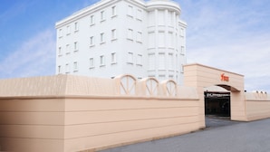 Un hôtel blanc à la façade incurvée, sur lequel on peut lire l’inscription « HÔTEL FIVE ».