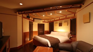 Une chambre d’hôtel avec un lit, un banc en bois, un canapé et un bureau.