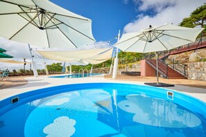Una piscina al aire libre de temporada, camas de piscina con cargo
