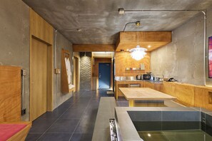 Une cuisine moderne dotée d’un plan de travail en bois, d’un évier et d’un four à micro-ondes encastré.