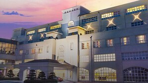 A large industrial-style building with multiple levels and large windows, featuring the name 'MAUNAVI' prominently displayed at the entrance. - The Mauna Ocean Resort (Gyeongju)