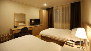 A hotel room with two beds, a desk with a chair, a TV, a bedside lamp, and a telephone. - Palgong Emillia Hotel (Daegu)