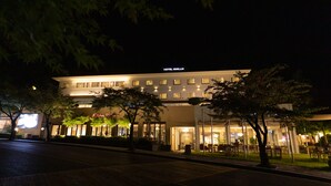 A hotel with a modern facade, illuminated windows, and outdoor seating area. - Palgong Emillia Hotel (Daegu)