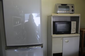 A kitchen with a refrigerator, a microwave, and a stove. - Share House Miyabi (Hakodate)