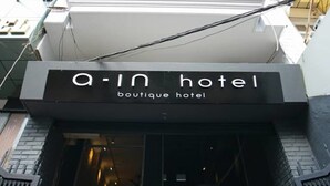 The entrance to a boutique hotel with a modern design, featuring a prominent sign above the door. - A in Hotel (Ho Chi Minh City)