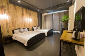 A hotel room with two beds, a wooden wall, a desk with a kettle, and a TV. - A in Hotel (Ho Chi Minh City)