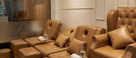 Un moderno spa con asientos de cuero, un separador de vidrio y un espejo grande.