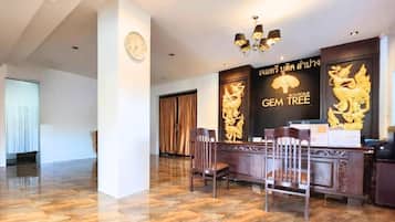 A reception area with a reception desk, chairs, a clock, and a wall with a logo and text.