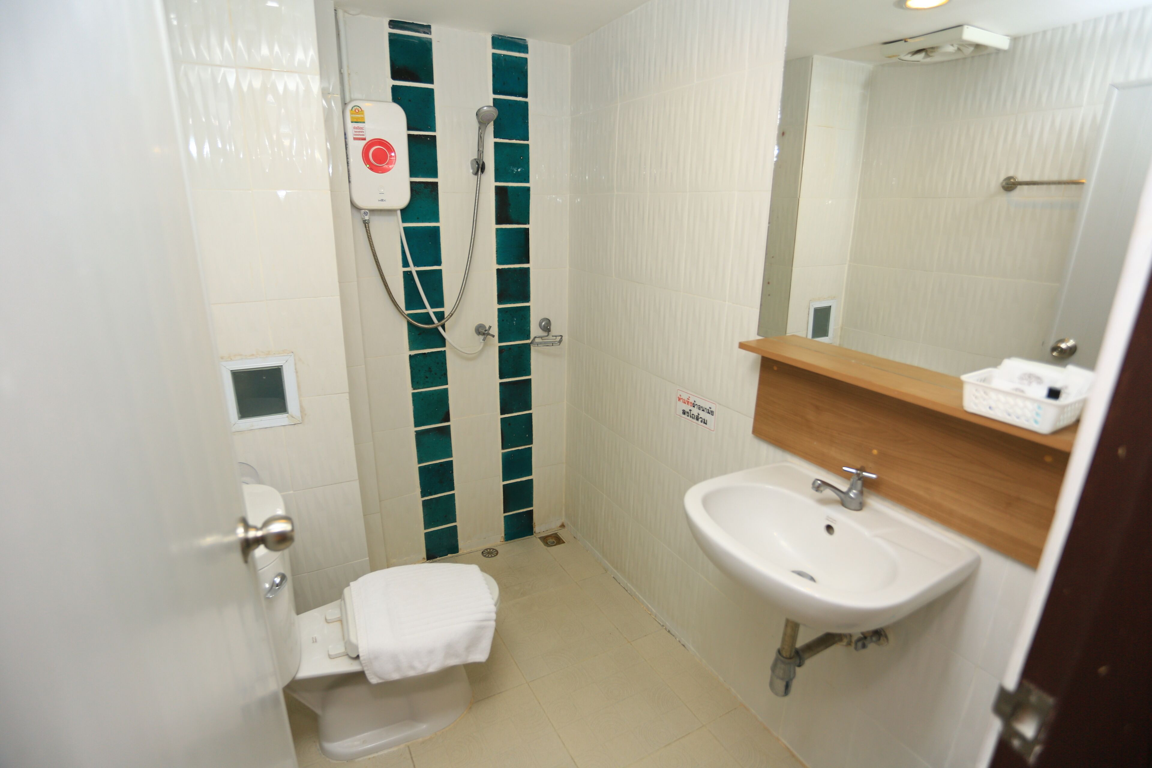 A small bathroom with a toilet, a sink, and a shower.