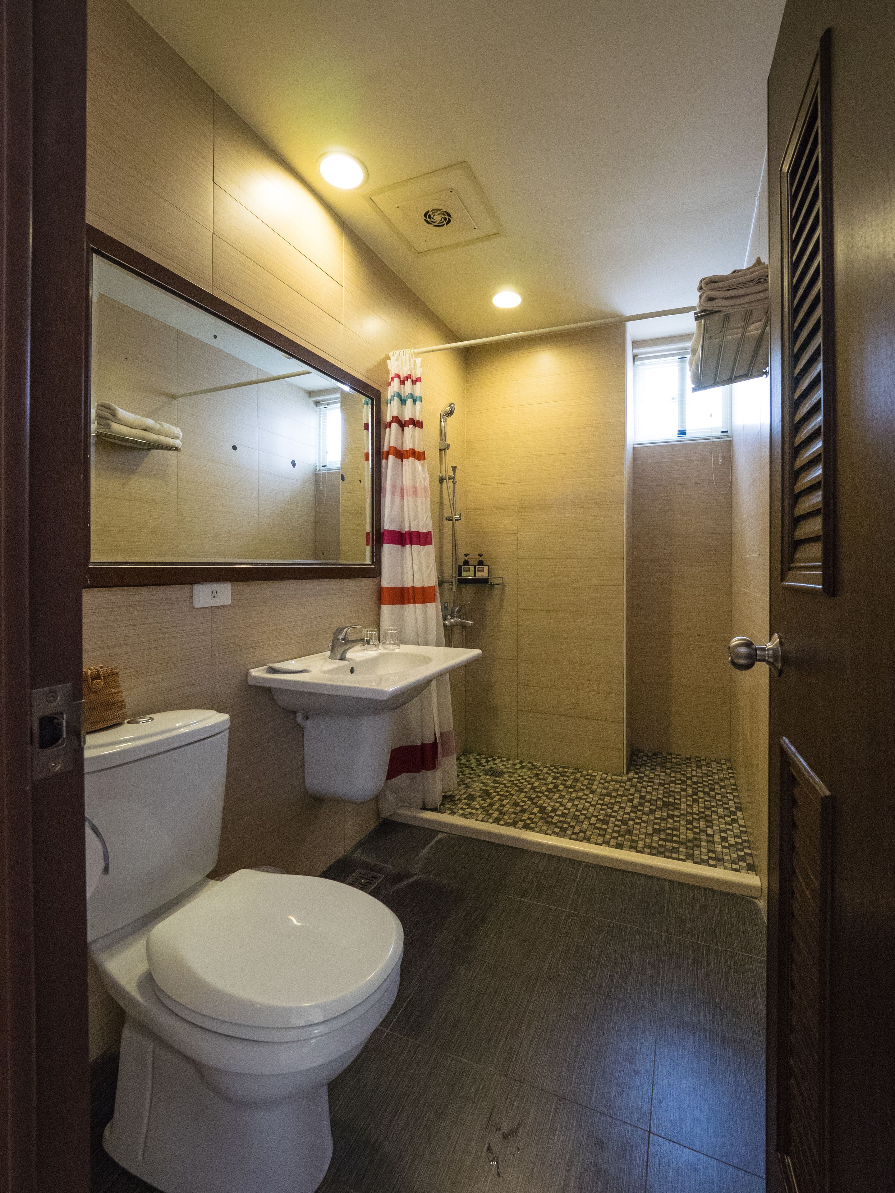 A bathroom with a toilet, sink, and shower.