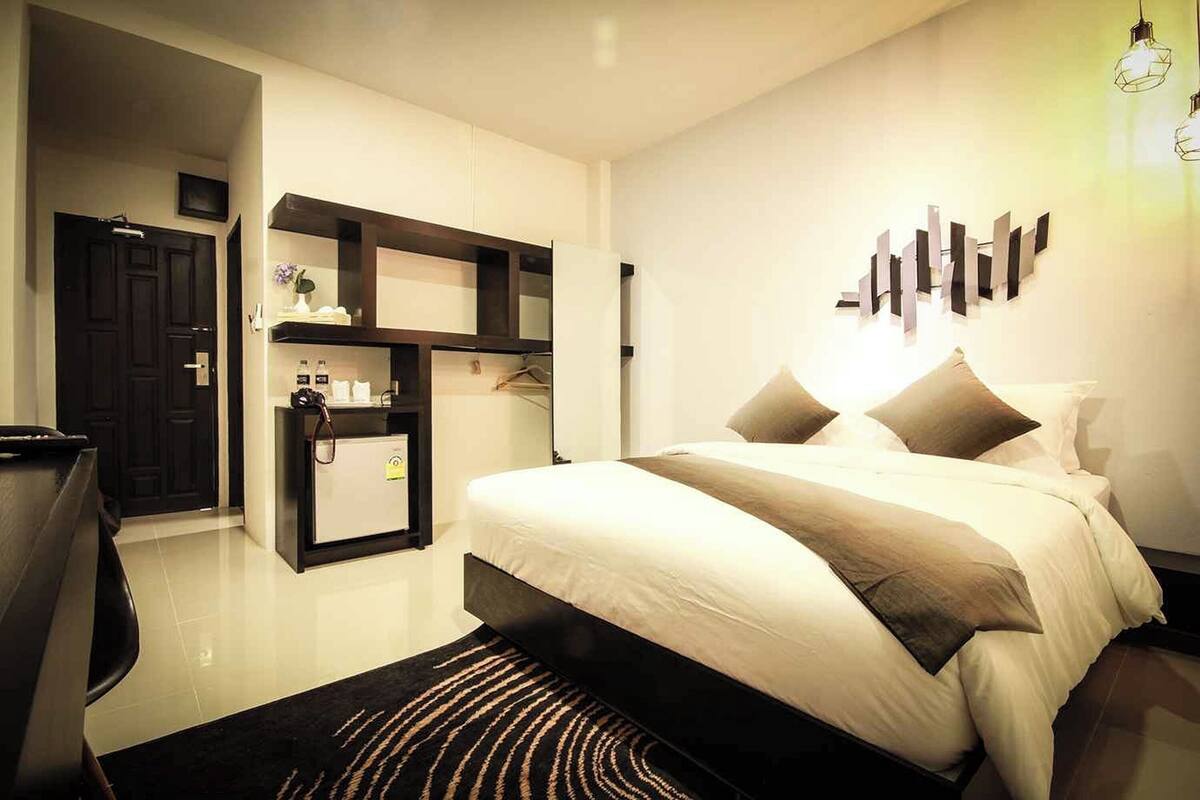 Ein modernes Schlafzimmer mit Bett, Kleiderschrank und Schreibtisch mit Stuhl.