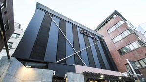 Moderni hotelli, jonka julkisivussa on suuri, huomiota herättävä kyltti, jossa lukee: ”HOTEL BLAND”.