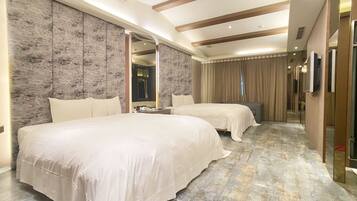 A hotel room with two beds, a large mirror, a wardrobe, and a carpeted floor.
