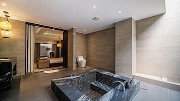 Un baño moderno con lavamanos de mármol, ducha integrada y un espejo grande.