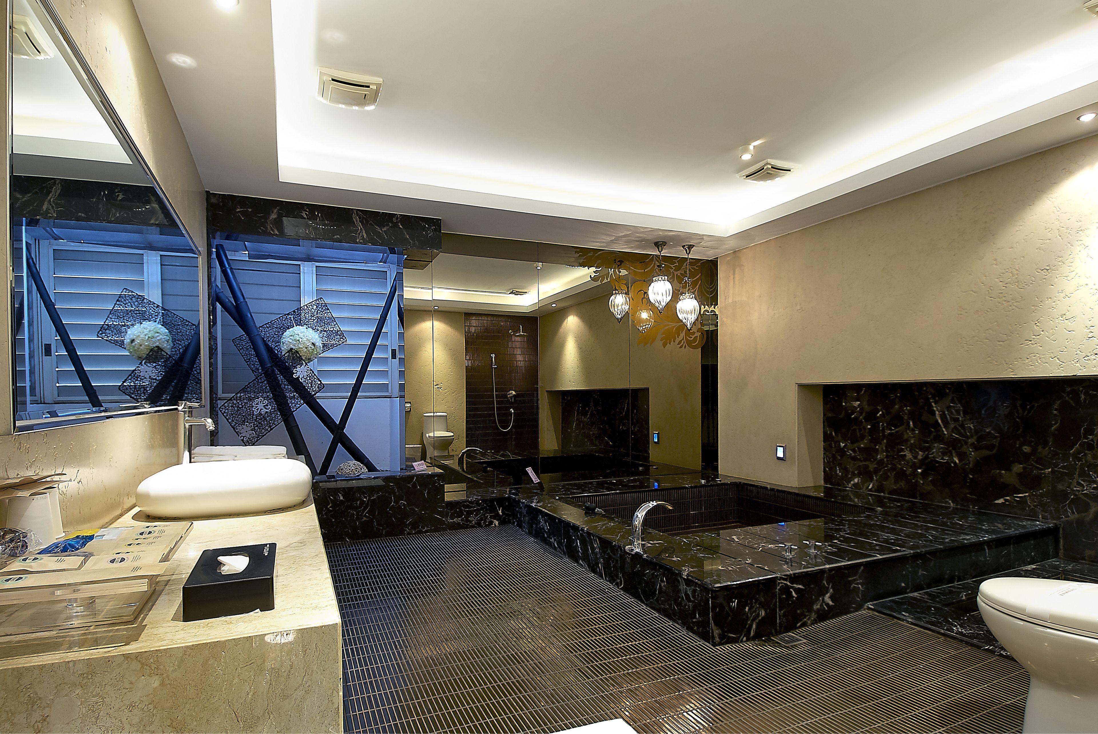 A modern bathroom with a large bathtub, a separate shower area, and a vanity with a marble countertop.