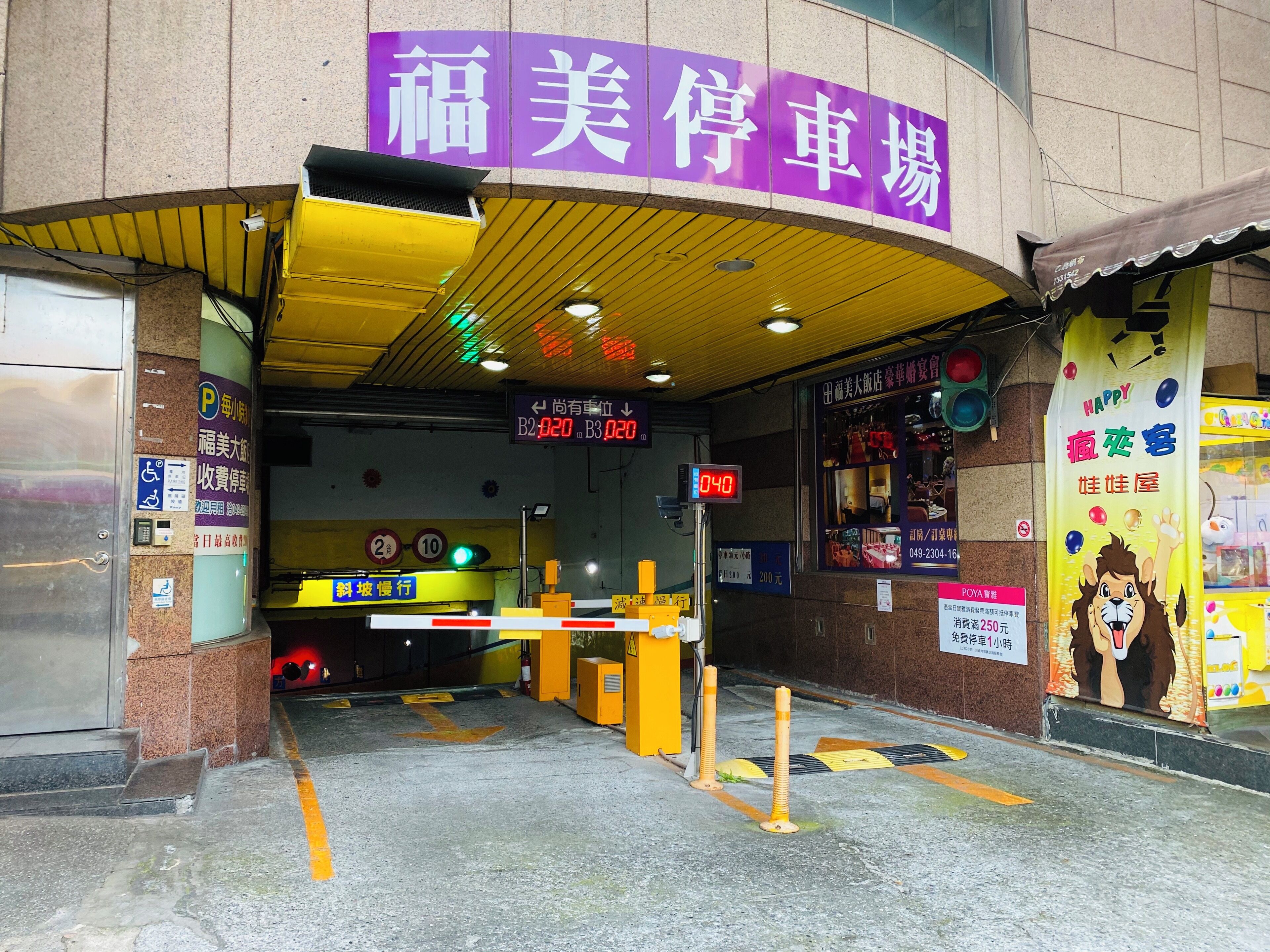 A parking garage entrance with a purple sign, a digital clock, and a yellow canopy.