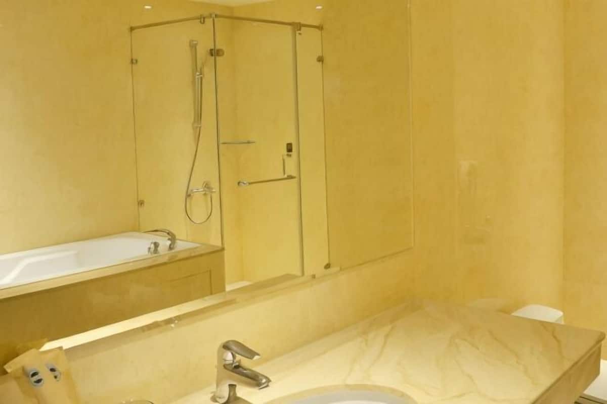 A bathroom with a bathtub, a shower, and a sink.
