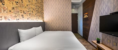 A modern hotel room with a large bed, a TV, and a wall decorated with butterfly illustrations.