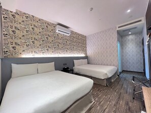 A hotel room with two beds, a patterned wall, an air conditioning unit, and a wooden floor.