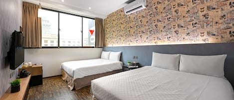 Une chambre d’hôtel avec deux lits, une télévision, un bureau et une grande fenêtre avec des rideaux.