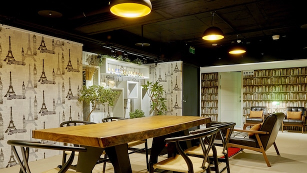 A conference room with a long wooden table, chairs, and a bookshelf filled with books. - Bon Hotel Taipei (Taipei)