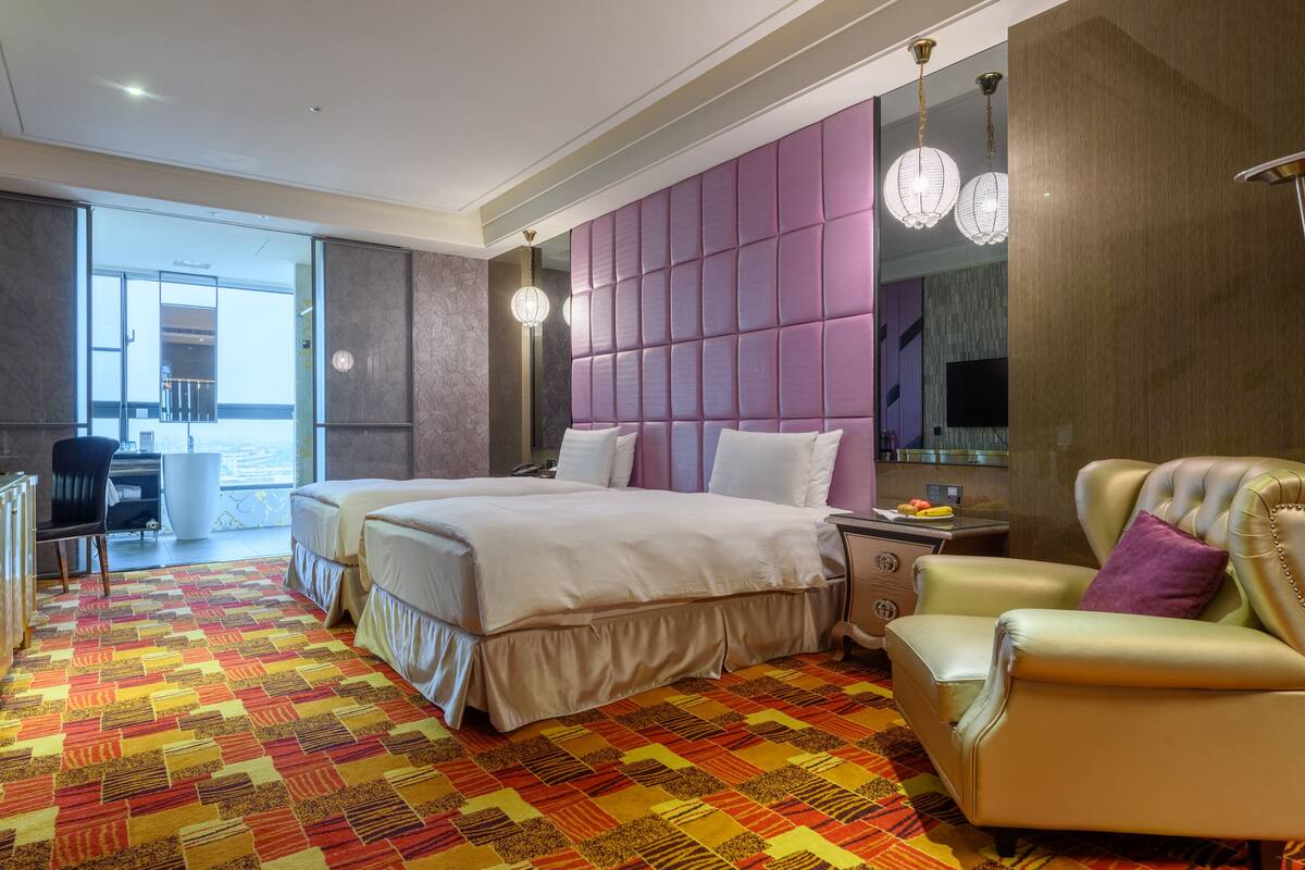 Une chambre d’hôtel avec un grand lit, un bureau, une chaise et un canapé.