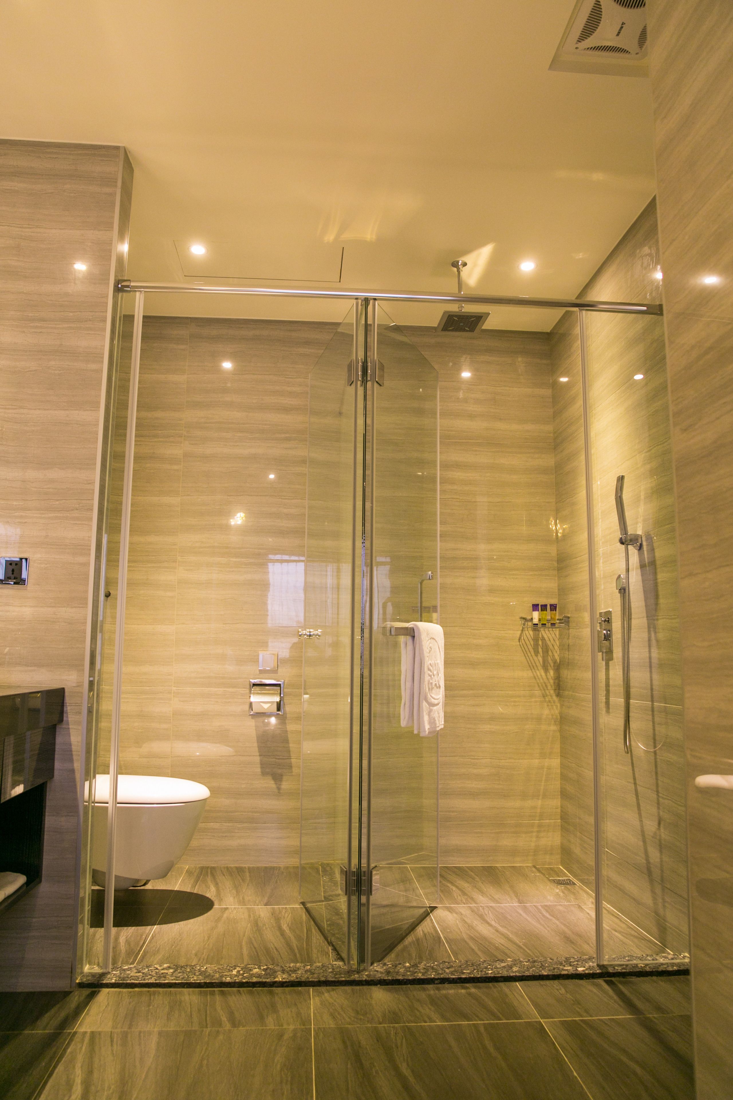 Un baño moderno con ducha envuelta en vidrio, inodoro y tocador.