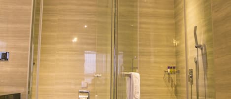 Un baño moderno con ducha envuelta en vidrio, inodoro y tocador.