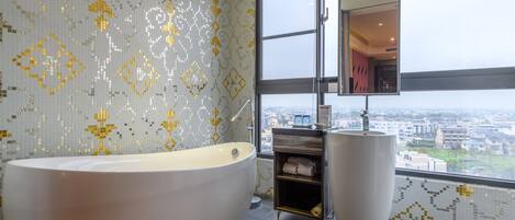 A modern bathroom with a freestanding bathtub, a large mirror, and a view of the city through a large window.