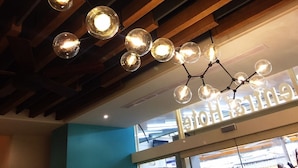 A ceiling with exposed wooden beams and a modern pendant light fixture with spherical glass bulbs.
